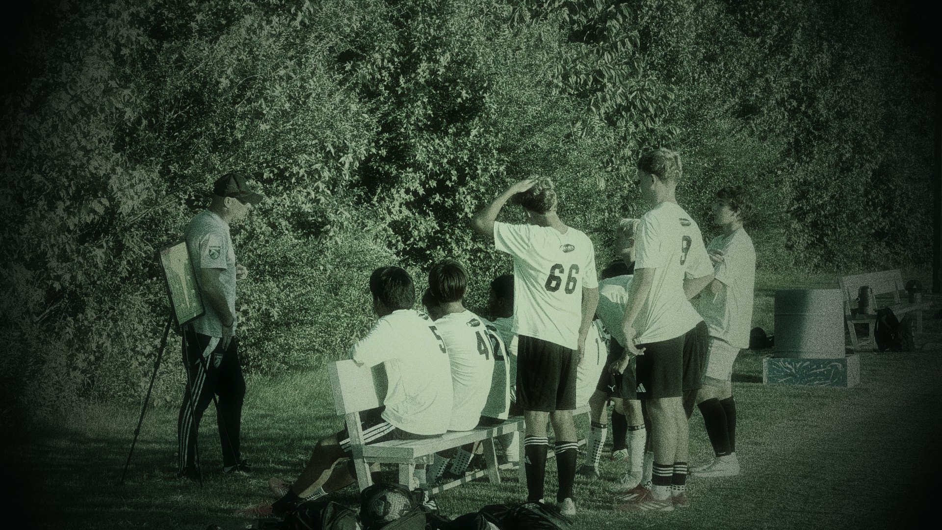 Legends players on the bench listening to their coach at dusk